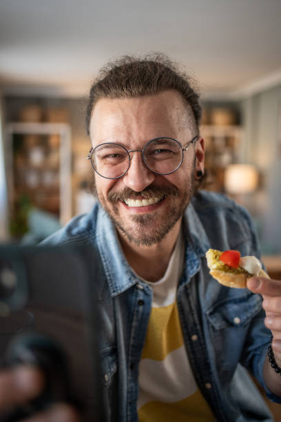 istock Hipster guy captures the moment with bruschetta in hand while taking a selfie 2184782062