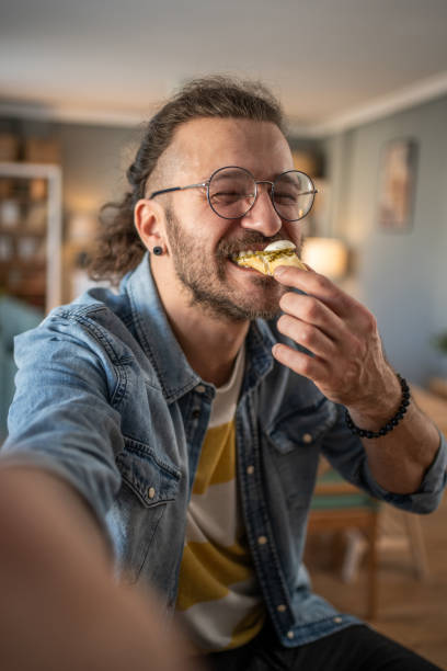 istock Hipster guy captures the moment with bruschetta in hand while taking a selfie 2184782073