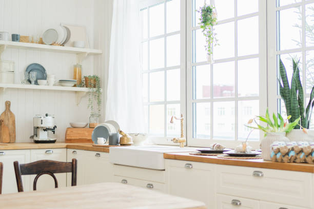 istock Empty white wooden kitchen interior with dining room. Scandinavian classic minimalistic bright kitchen with white and wooden details. Modern white kitchen clean contemporary style interior design. 2184782683