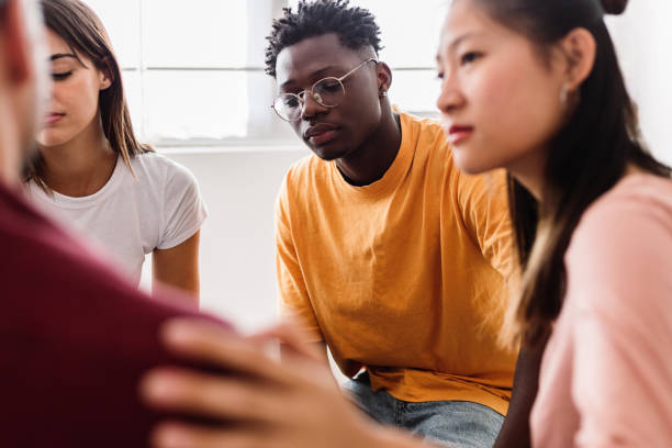 Therapy group people supporting each other talking at community center stock photo
