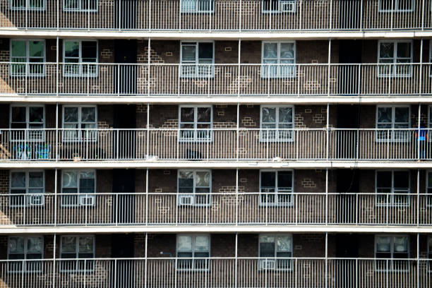 Rows and rows of balconies on a brown stone building, lined with white railings.