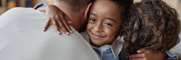 istock Header Image of Smiling Black Boy Looking at Camera while Hugging Adoptive Parents Indoors 2184789285