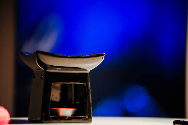 A beautiful candle holder is elegantly placed on a table that features a captivating blue background that enhances its appeal