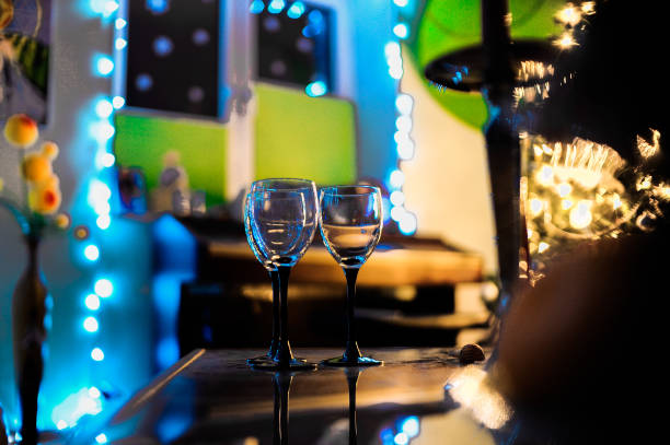 istock Two elegant wine glasses sit on a table in a dark room, sophisticated 2184790324