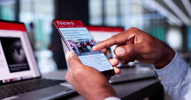 istock Watching Online News Article On Mobile Phone And Laptop 2184790874