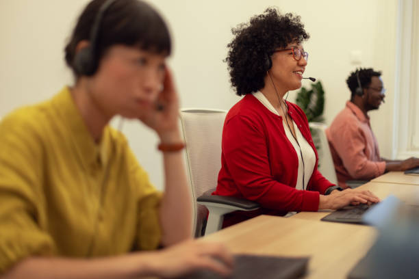 istock A diverse team of call center representatives sitting next to each other in the same office while talking to international customers 2184792697