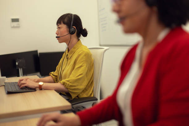 istock Two diverse women work together in a call center office 2184792734