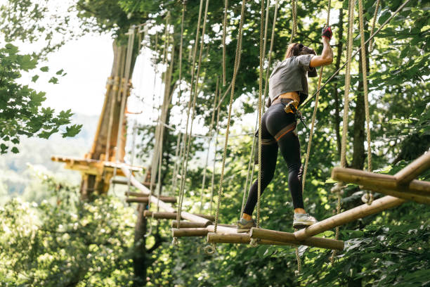 istock An Adventurous Woman Engaged in a Challenging Tree Climbing Course Surrounded by Nature 2184794118