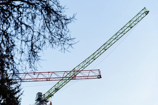 istock Construction cranes on a background of sky and wood. 2184794990