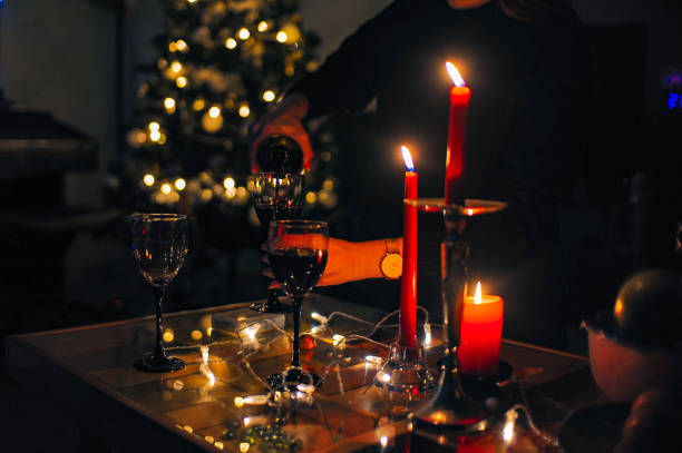 istock A person pours wine into a glass on a table with candles and a tree 2184795089