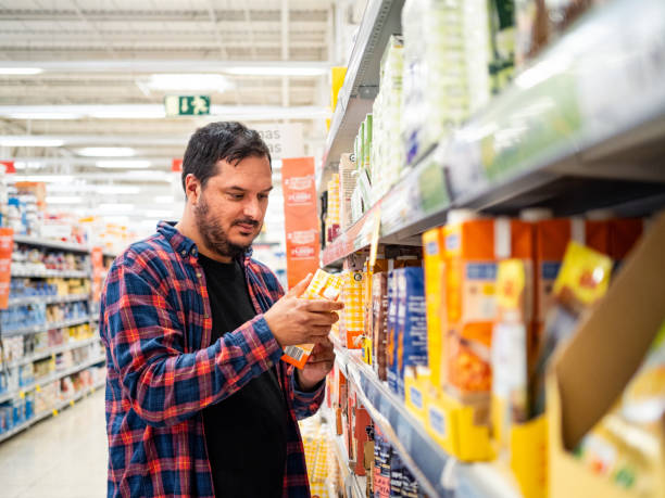 istock Man examines a product in a grocery store aisle 2184797445