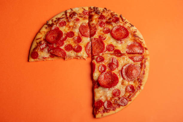 istock pepperoni pizza on orange color background 2184797957