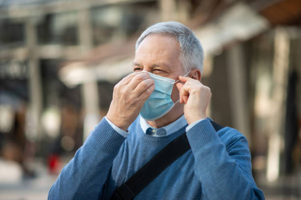 istock Senior man wearing protective face mask outdoors in the city 2184800862
