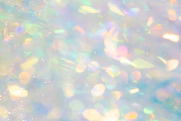 A softly blurred, pastel-colored glitter background sparkles with ethereal beauty, where shimmering lights and subtle rainbow hues blend together.