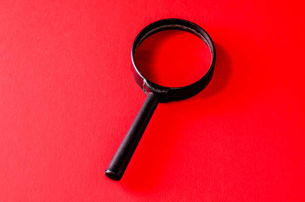 istock A black magnifying glass is on a red background 2184804274