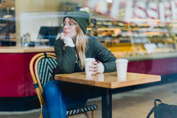 istock Woman Holding Coffee Cup in Coffee Shop 2184804768