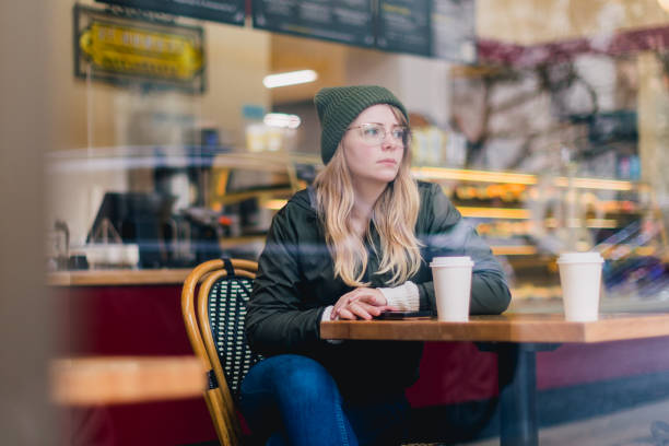 istock Woman Holding Coffee Cup in Coffee Shop 2184804782