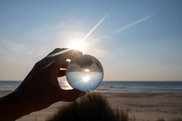 istock Beach and sea reflected in a ball in a human hand 2184810688