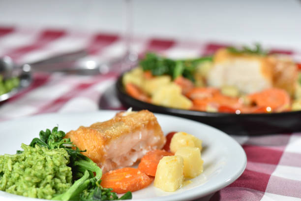 codfish typical Portuguese dish baked cod with onion garlic peppers and potatoes rustic Portuguese food salted fish cooked olive oil