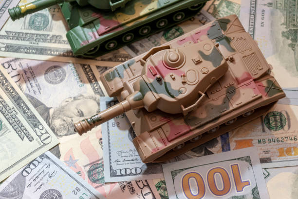 istock tanks against a backdrop of dollar notes symbolising US military spending. 2184815352