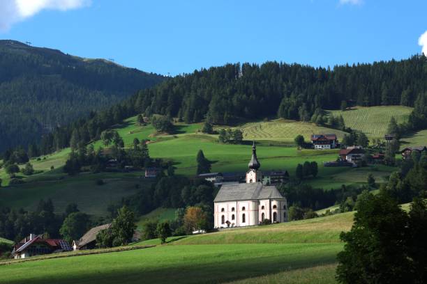 istock Charming white church with steeple in green hills 2184818033