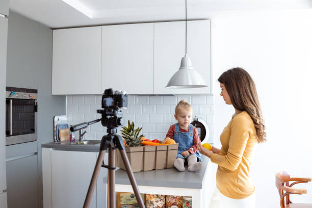 istock Mother and toddler filming social media content in modern kitchen setting 2184826514