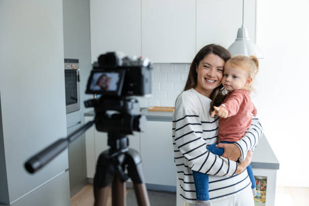 istock Smiling mother recording video with daughter in modern kitchen 2184826602
