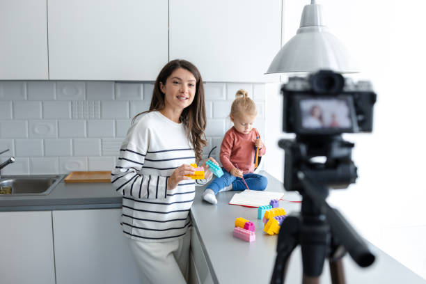 istock Mother recording vlog with baby in kitchen setting 2184826613
