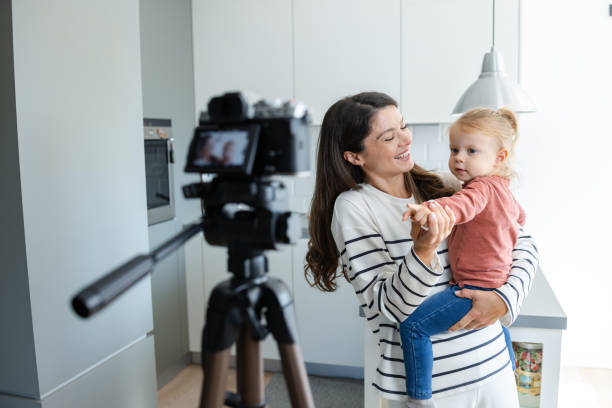 istock Smiling mother recording video with daughter in modern kitchen 2184826651