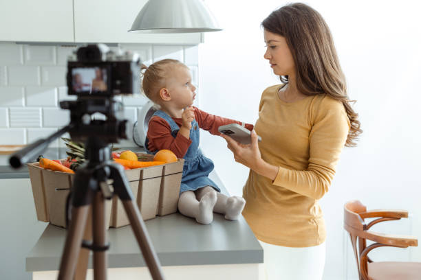 istock Mother vlogging with toddler in modern kitchen 2184826680