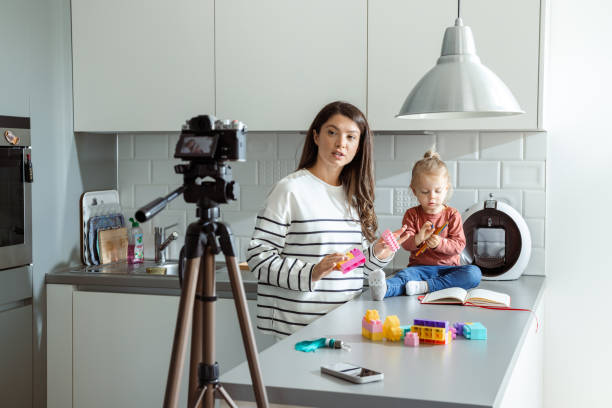 istock Mother and daughter creating online content in a cozy kitchen 2184826715