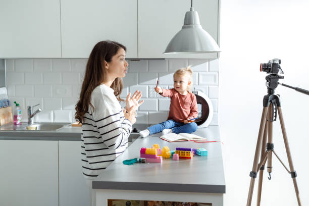 istock Mother filming toddler in kitchen setting with playful interaction 2184826716