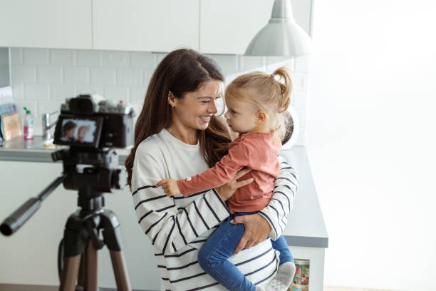 istock Mother and daughter smiling while recording a video at home 2184826770