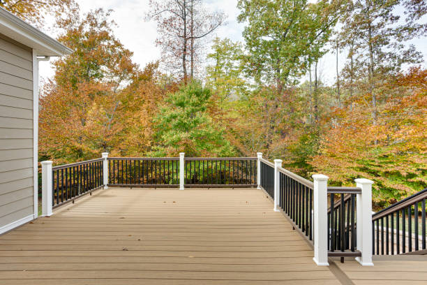 Spacious Wooden Deck Overlooking Autumn Forest View A spacious wooden deck attached to a house, bordered by a simple railing and overlooking a vibrant autumn forest, capturing the essence of tranquility and nature's beauty. house railing stock pictures, royalty-free photos & images