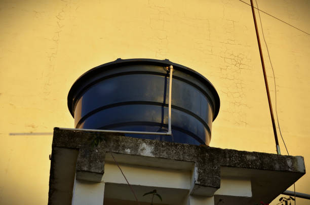 A large navy blue water tank on top in the late afternoon