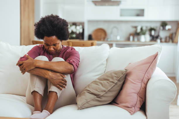 istock Woman Sitting on Couch Looking Sad and Stressed at Home 2184839192
