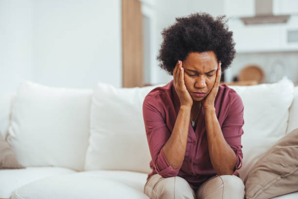 istock Worried Woman Sitting On Couch At Home Feeling Stressed 2184839195