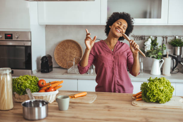 Joyful Woman Singing While Cooking Healthy Meal in Kitchen