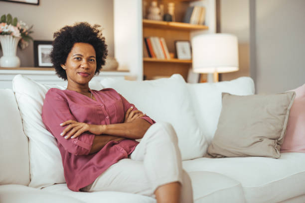 istock Confident Woman Relaxing on Cozy White Sofa at Home 2184839258