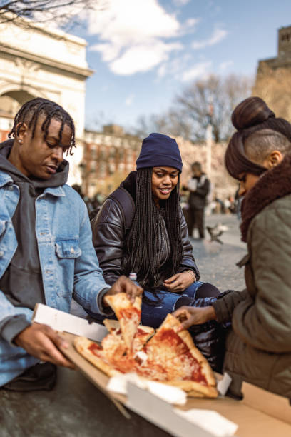 istock Friends Enjoying Pizza Outdoors on a Sunny Afternoon. Washington Square Park 2184841856