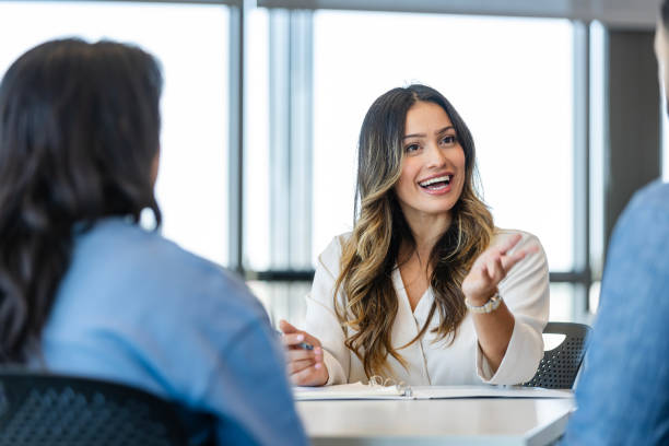 istock Cheerful loan officer talks with customers 2184842024