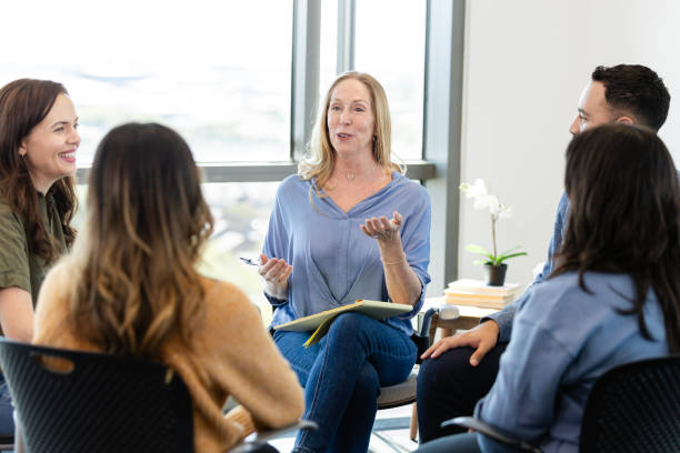istock Female therapist gives advice during group therapy meeting 2184842118