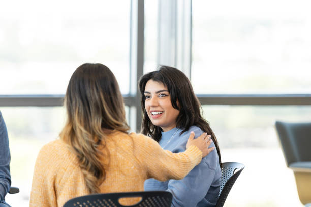 istock Young woman is encouraged during support group meeting 2184842123