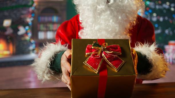 istock Saint Nicholas prepares a festive gift box by the fire in workshop 2184843104