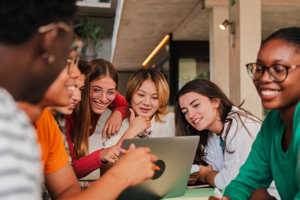 istock Diverse group of teenage students studying together in a library, collaborating on a project using a laptop, fostering teamwork and communication. Classmates doing a research with a computer 2184848735