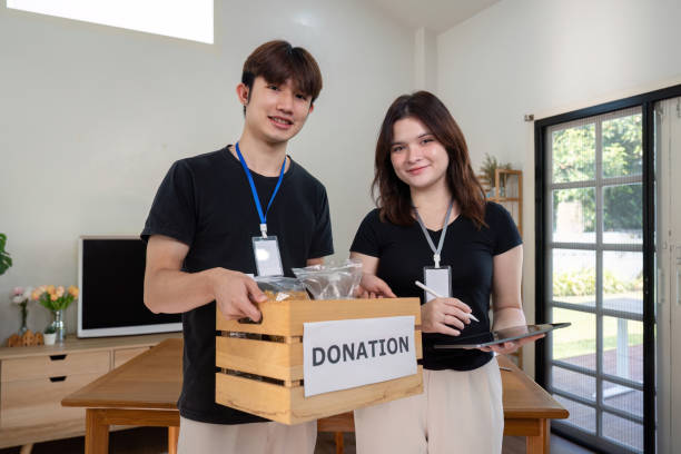 istock Smiling Volunteers Promoting Charitable Efforts with Donation Boxes 2184850938
