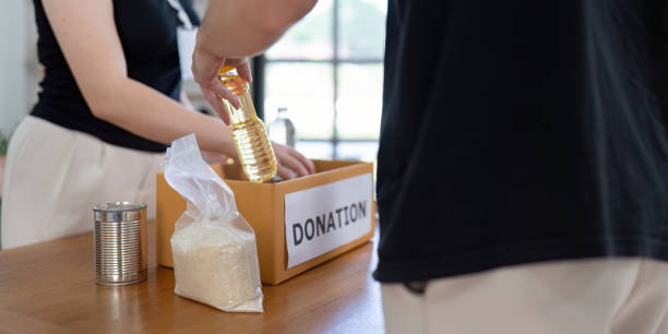 istock Hands On Team Packing Essential Groceries for Donation Box 2184850969