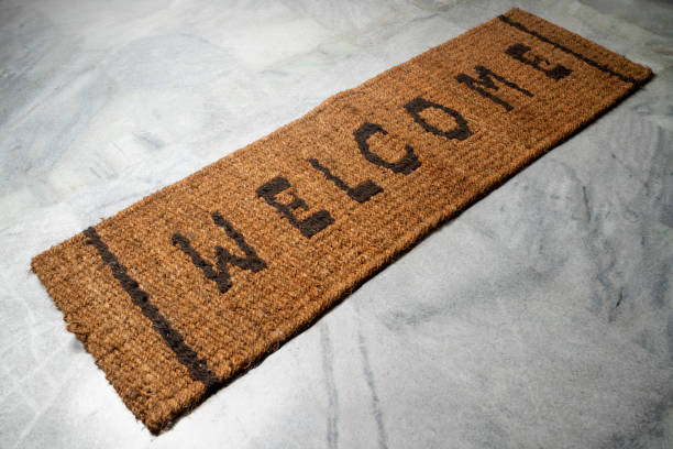 istock Brown doormat with welcome text on it with floor background 2184852795