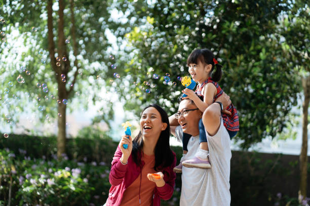 istock Asian Chinese family playing bubbles in public park 2184853267