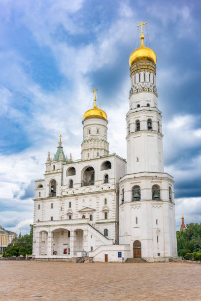 Ivan the Great Bell Tower, with Assumption Belfry on the right in Moscow Kremlin. Blue sky background with sunbeams